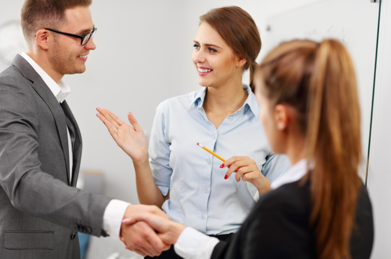 A personal referral from one person to another. Two people are shaking hands with someone in-between to introduce them